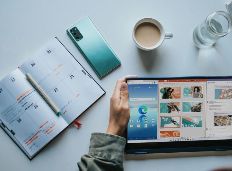 person using Windows 11 computer beside white ceramic mug on white table