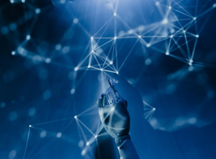 Free A robotic hand reaching into a digital network on a blue background, symbolizing AI technology. Stock Photo