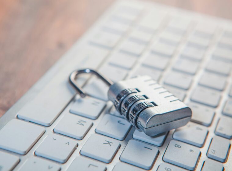 A combination lock rests on a computer keyboard.